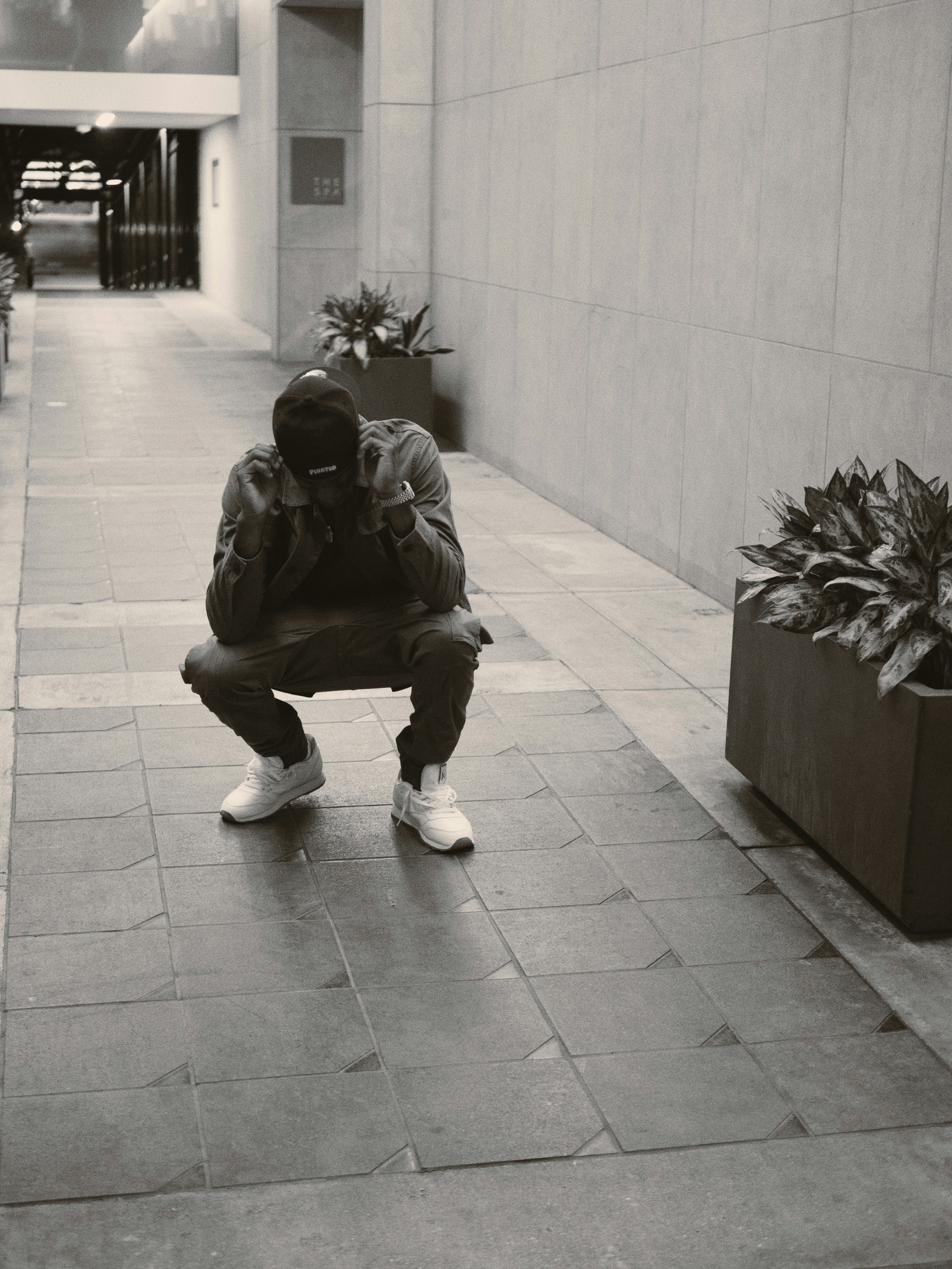 man in black jacket sitting on concrete bench